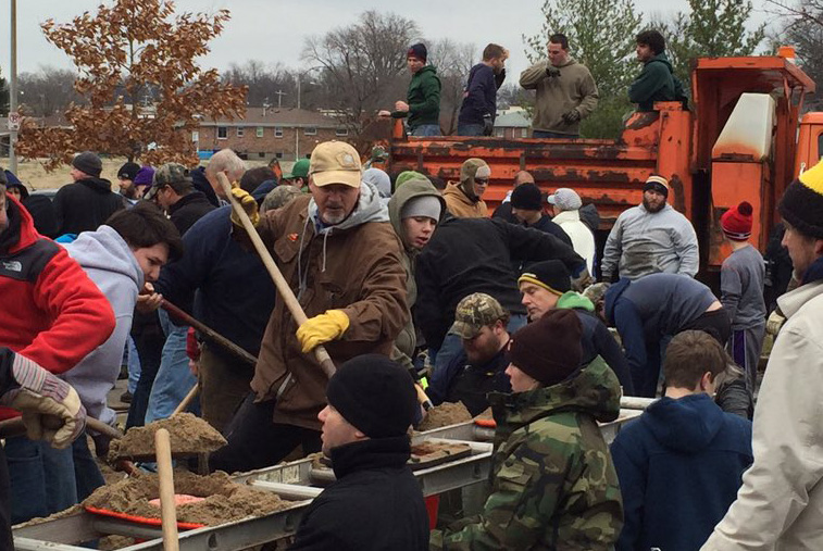 Volunteers load sand bags for the River Des Peres Levee